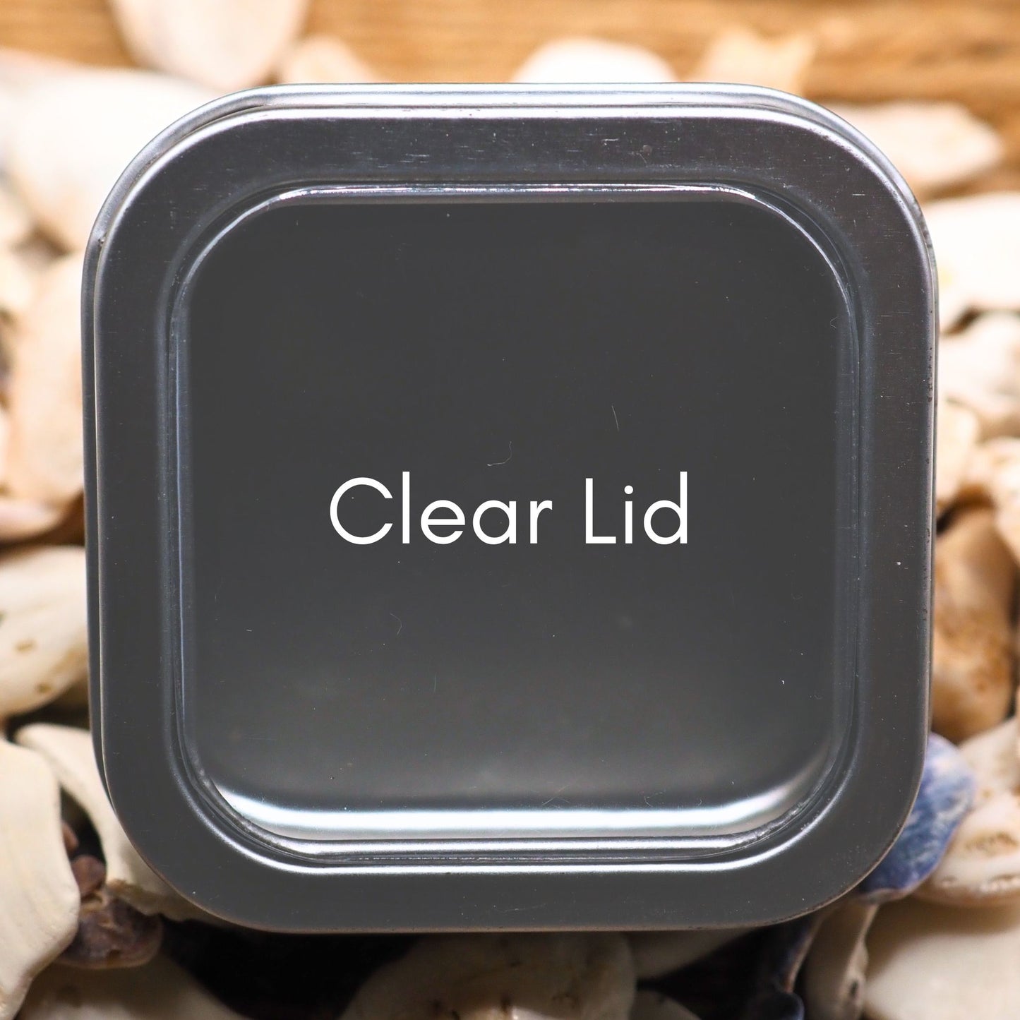Square metal tin with clear lid close up 