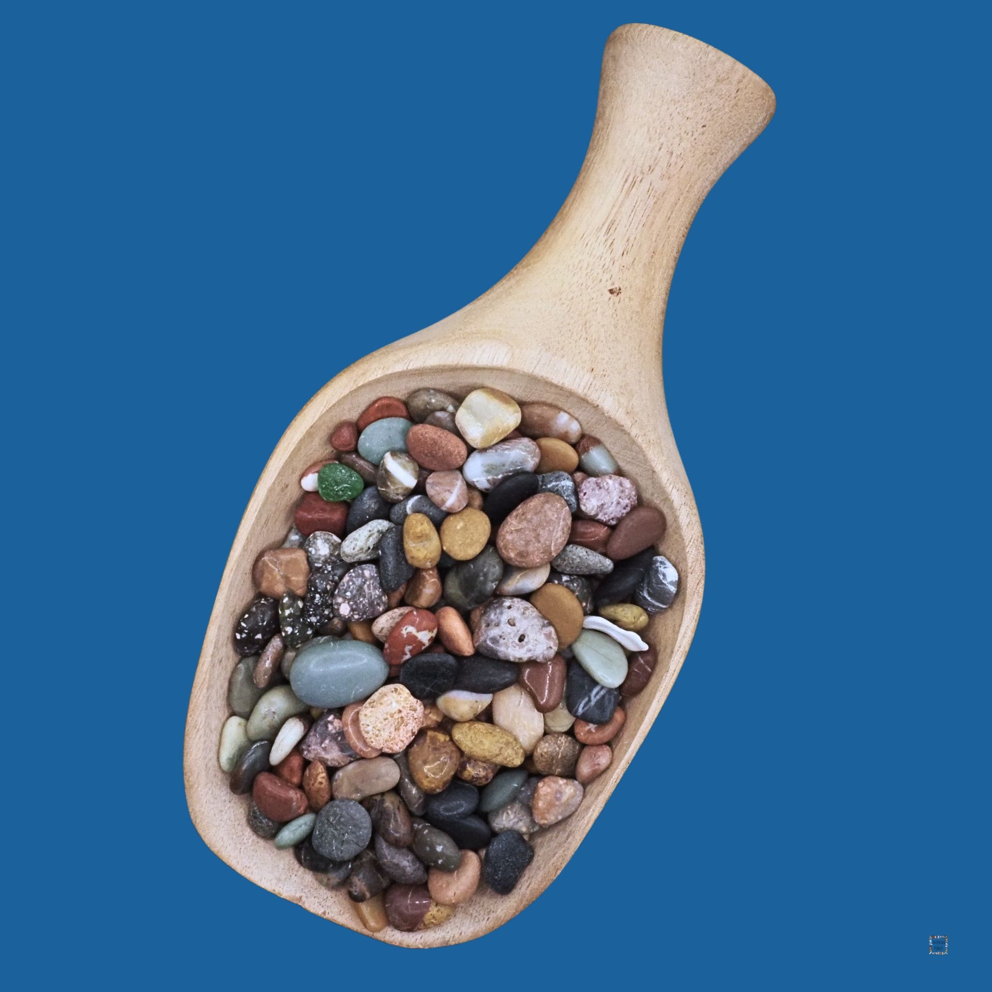 Colorful mini sea pebbles in giant wooden scoop